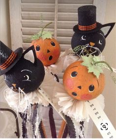 three pumpkins decorated as witches and cats