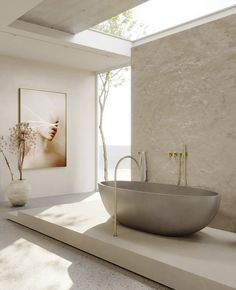 a bath tub sitting on top of a white counter next to a vase filled with flowers