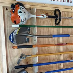 tools are lined up on a wooden shelf