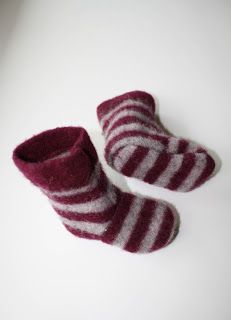 two pairs of striped slippers sitting on top of a white table next to each other