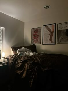 a bedroom with posters on the wall and a bed covered in a brown comforter