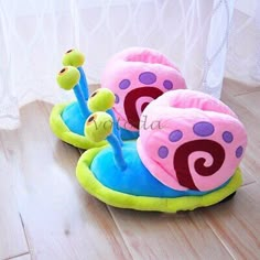 two children's slippers sitting on top of a wooden floor