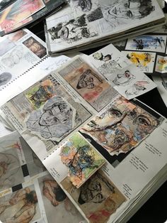 many drawings are spread out on the table