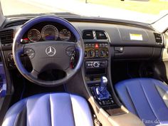 the interior of a car with blue leather seats and steering wheel, including an automatic