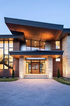 a large modern home with stone and wood accents