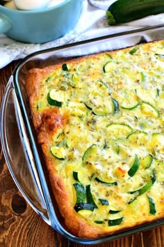 a casserole with zucchini and cheese in a pan on a wooden table