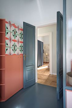 an open door leading to another room with blue and pink accents on the walls,