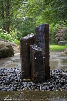 an outdoor fountain with rocks and stones around it