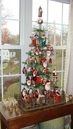 a christmas tree with ornaments on it in front of a window