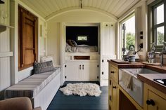 a kitchen area with a bench, sink and window in the back side of the house