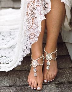 a woman's feet wearing barefoot sandals and bracelets with pearls on the toes