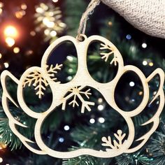 a wooden ornament shaped like a dog paw with snowflakes on it