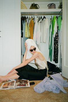 a woman sitting on the floor in front of a closet