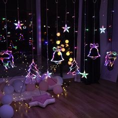 some lights that are hanging from strings in the air on a wooden floor near a window