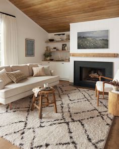 a living room filled with furniture and a fire place under a wooden ceiling mounted above a fireplace