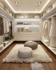 a walk in closet with white furniture and lighting