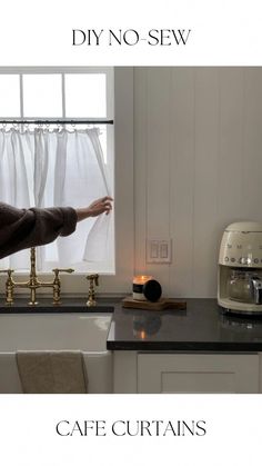 a woman standing in front of a window next to a counter top with a coffee pot on it