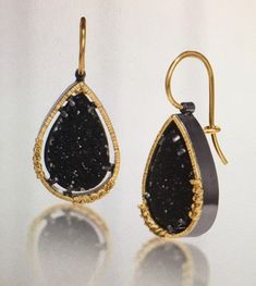 From Elizabeth Garvin's Spiral Collection, these #4 natural prong-set black druzy teardrop earrings in 18k gold are backed with oxidized sterling silver and feature surrounding natural yellow diamonds. As with every one of Ms Garvin's pieces, they are hand fabricated with hammer texturing. Earrings have 3/4" drop (1 1/4" with ear wires) and are 1/2" wide. The 18k yellow gold locking ear wires offer added security. Hand fabricated, hammer textured. Price is $1895. Elizabeth Garvin is known for her award winning bold signature style. She has operated out of her NYC studio since 1980. Elizabeth is both self-taught and a 1986 graduate of NYU, Parsons School of Design & Mass College of Art. A lifetime of studying stones, plants and ocean currents gives her beautifully melded pieces a modern sen Ocean Currents, Nyc Studio, Yellow Diamonds, Parsons School Of Design, American Modern, Druzy Earrings, Oxidized Sterling Silver, Yellow Diamond, Teardrop Earrings