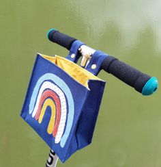 a blue bag with a handle attached to it sitting on top of a metal pole