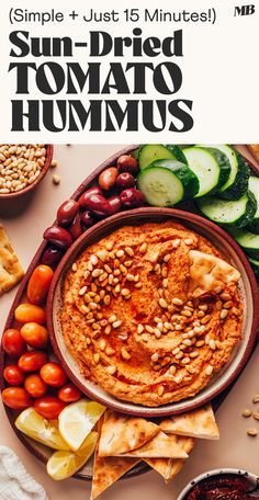 a plate full of hummus, cucumbers and other food on a table