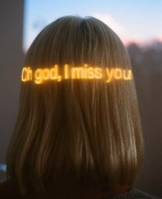 the back of a woman's head with words projected on her hair that spell out, oh god, i miss you