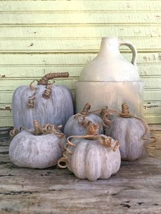 some white pumpkins are sitting next to a jug