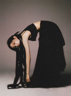 a woman in a black dress bending over