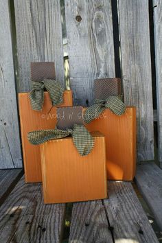 two wooden bags with bows on them sitting next to each other in front of a fence