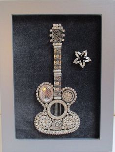 an ornate guitar is in a shadow box