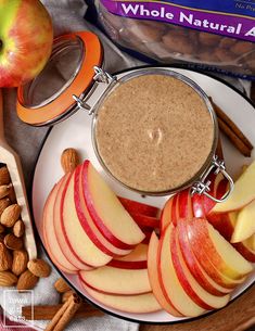 an apple and almond smoothie on a plate next to nuts, cinnamons and apples