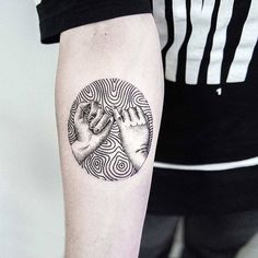 two hands holding each other in a circle tattoo on the right forearm and left arm