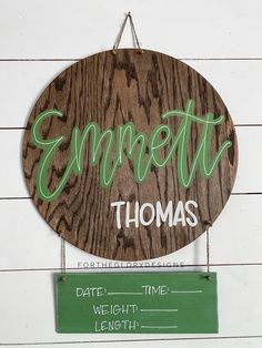 a wooden sign hanging from the side of a white wall next to a green sign