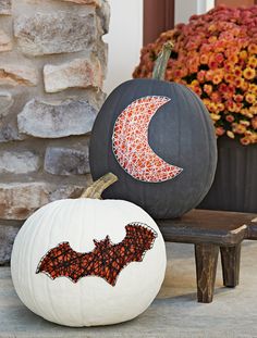 two pumpkins decorated with bat and moon designs