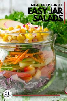 a glass jar filled with salads on top of a table