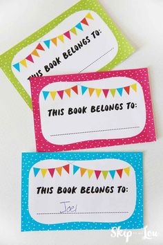 three book belongs cards with bunting flags on them