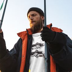 a man with a beard is holding two fishing rods