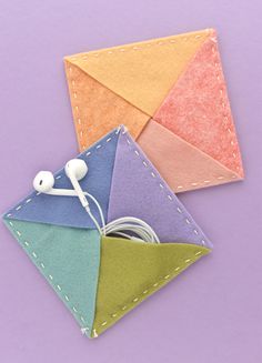 an origami piece with earphones attached to it on a purple table top