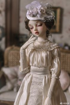 the doll is wearing a white dress and hat