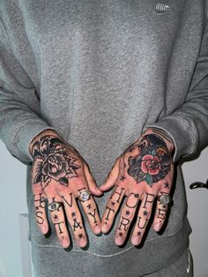 a person with tattoos on their hands and two fingers