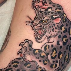 a tattoo on the leg of a person with a leopard