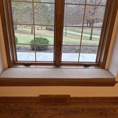 an open window in the corner of a room with wood trimming and white walls