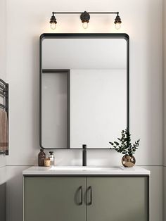 a bathroom vanity with a large mirror above it and two lights on the wall next to it