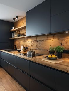 a kitchen with black cabinets and wooden counter tops is pictured in this image, there are lemons on the cutting board next to the sink