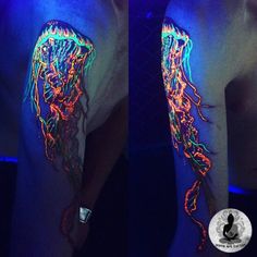 the arm is decorated with neon lights and jelly fish tattoos on it's arms