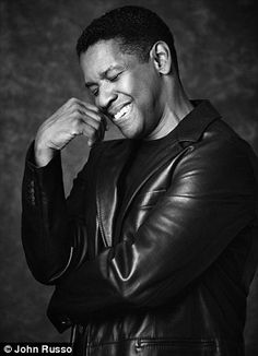 a black and white photo of a man in a leather jacket smiling at the camera