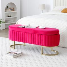 a pink bench sitting on top of a white rug next to a bed and nightstand