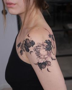 a woman with a flower tattoo on her arm and shoulder is looking at the camera