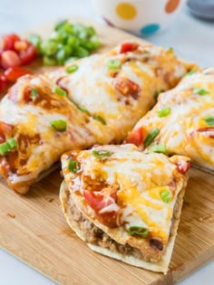 several pieces of pizza sitting on top of a wooden cutting board