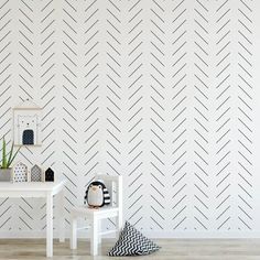 a white table and two chairs in front of a wall with chevron lines on it