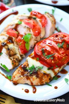 grilled chicken with tomatoes and mozzarella sauce on a white plate, garnished with parsley